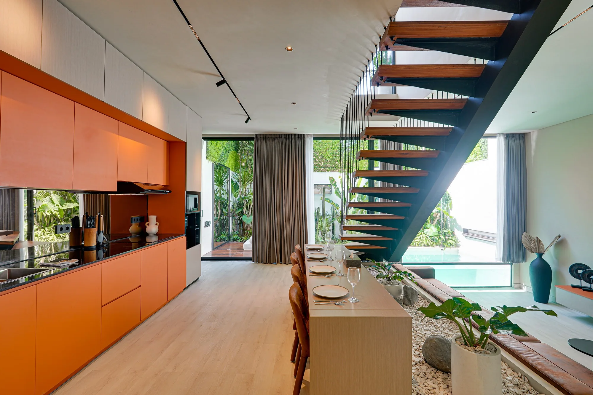 The kitchen with an orange accent and the stair in the villa living room