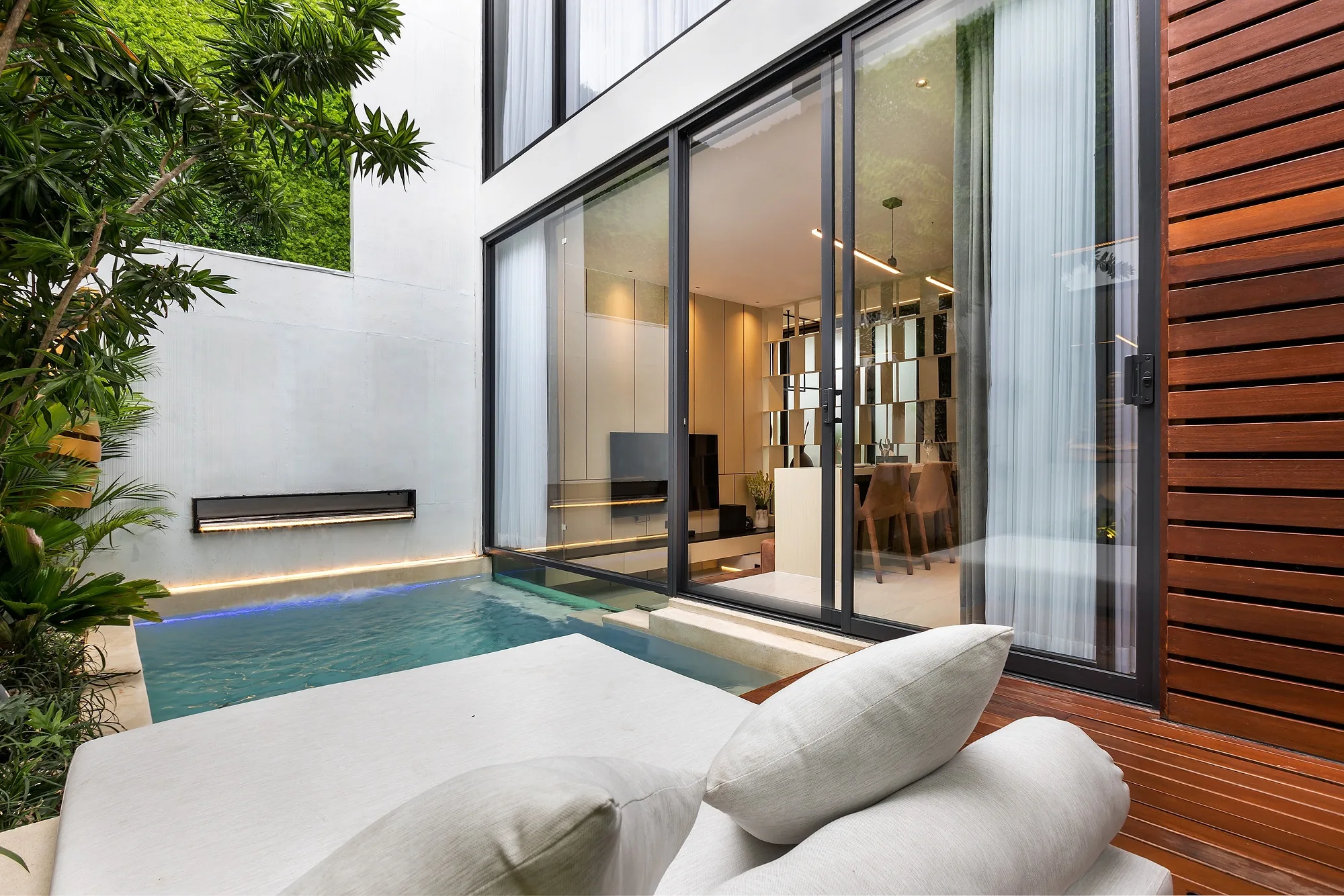 Villa living room opening to the courtyard with a view of the pool
