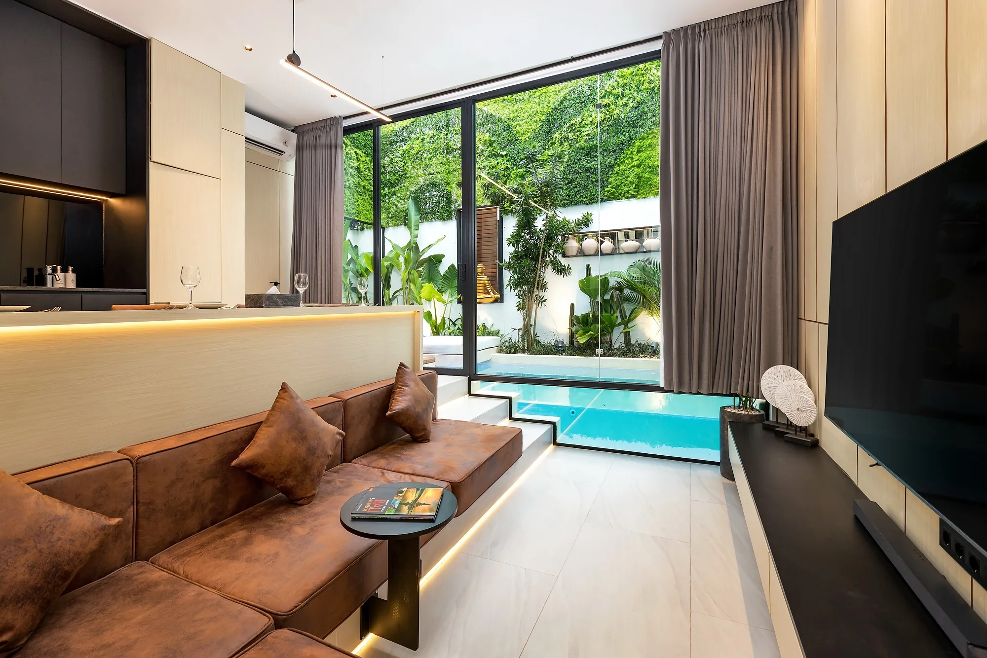 Living room with full-height glazing facing the courtyard pool