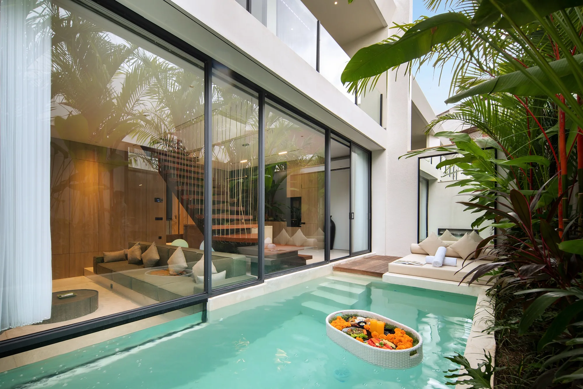 The villa courtyard: a ribbon pool along the full-height glazing with tropical planting around it
