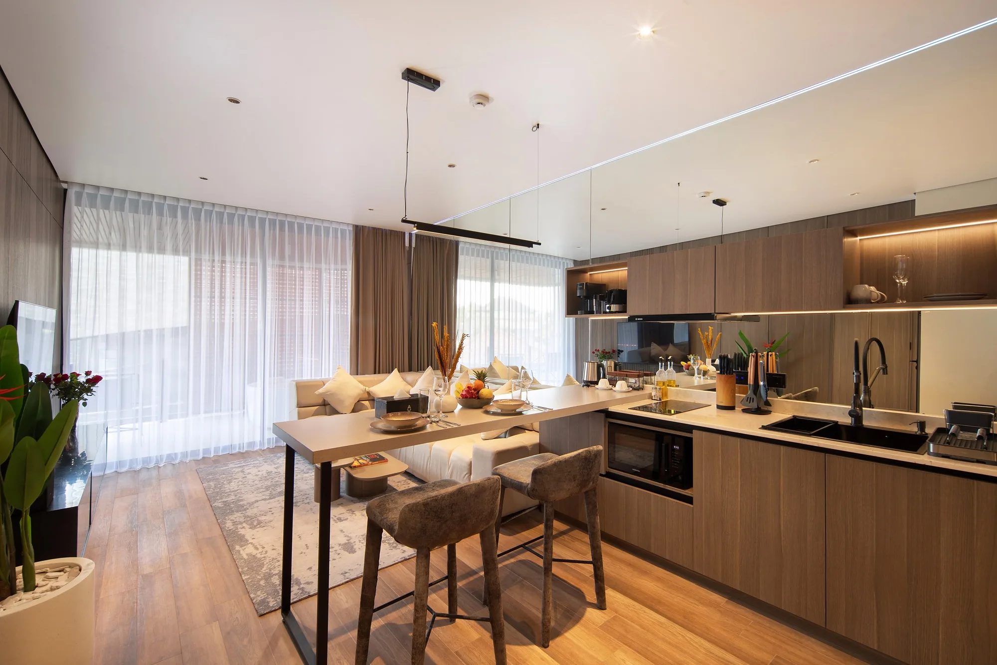 The apartment kitchen and dining area in pale timber