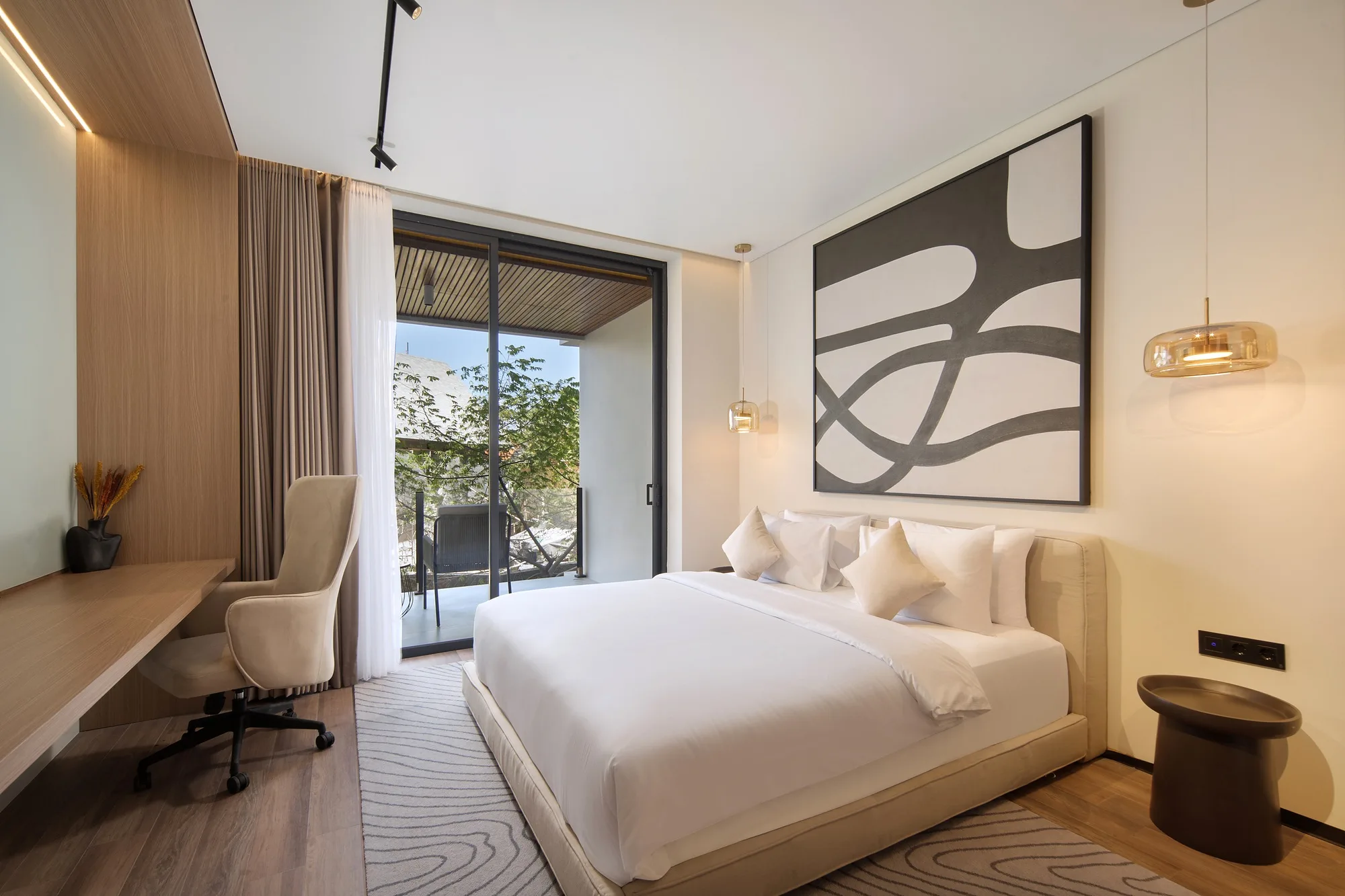 A bedroom with a desk by the window