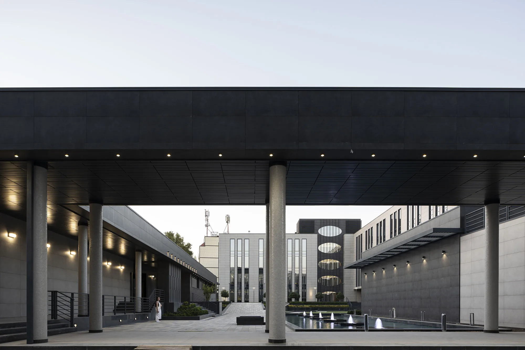Passage beneath a block of the business centre: a dark colonnade opening onto the courtyard