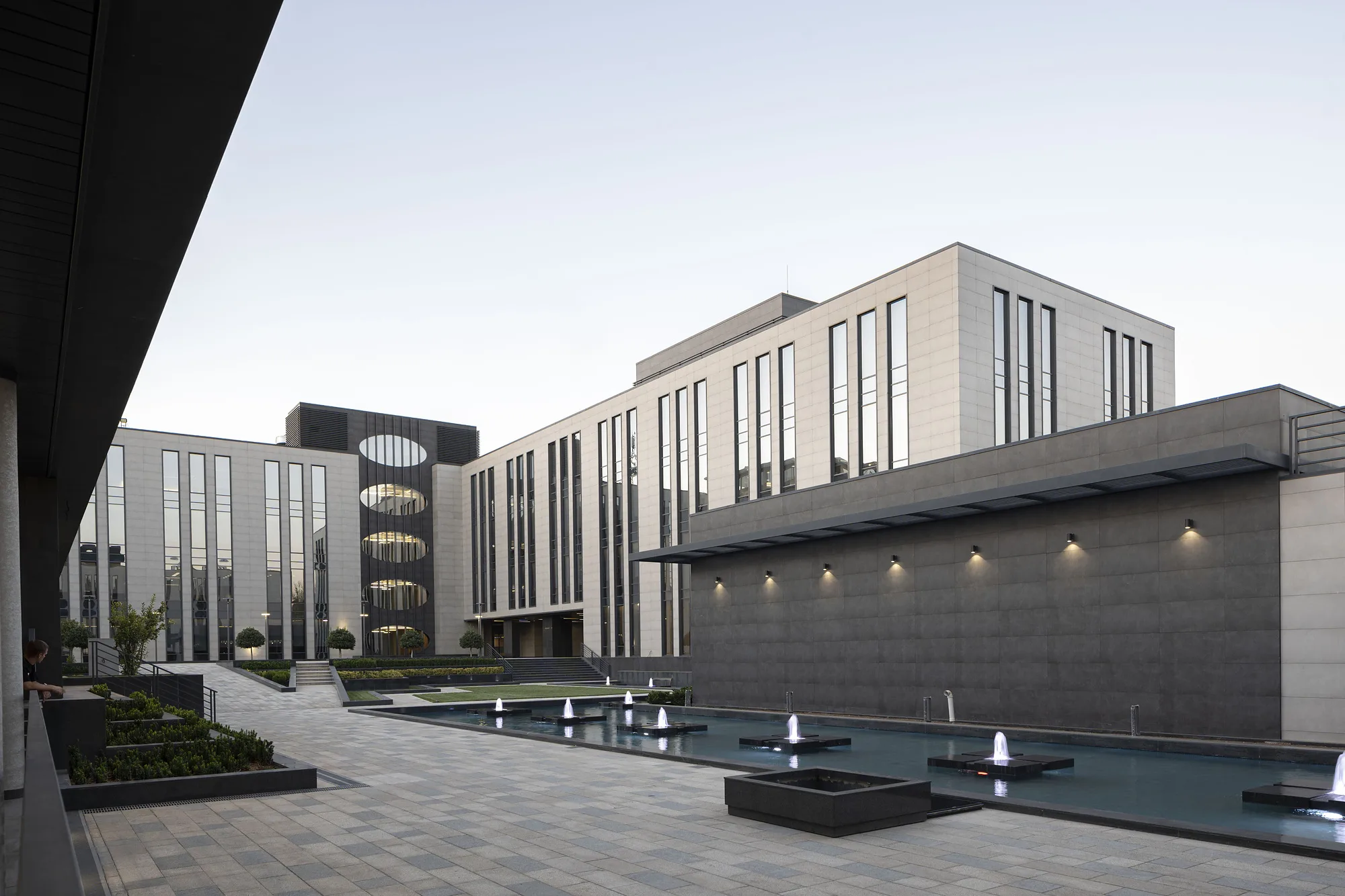 Blocks of the business centre and the fountain pool at dusk