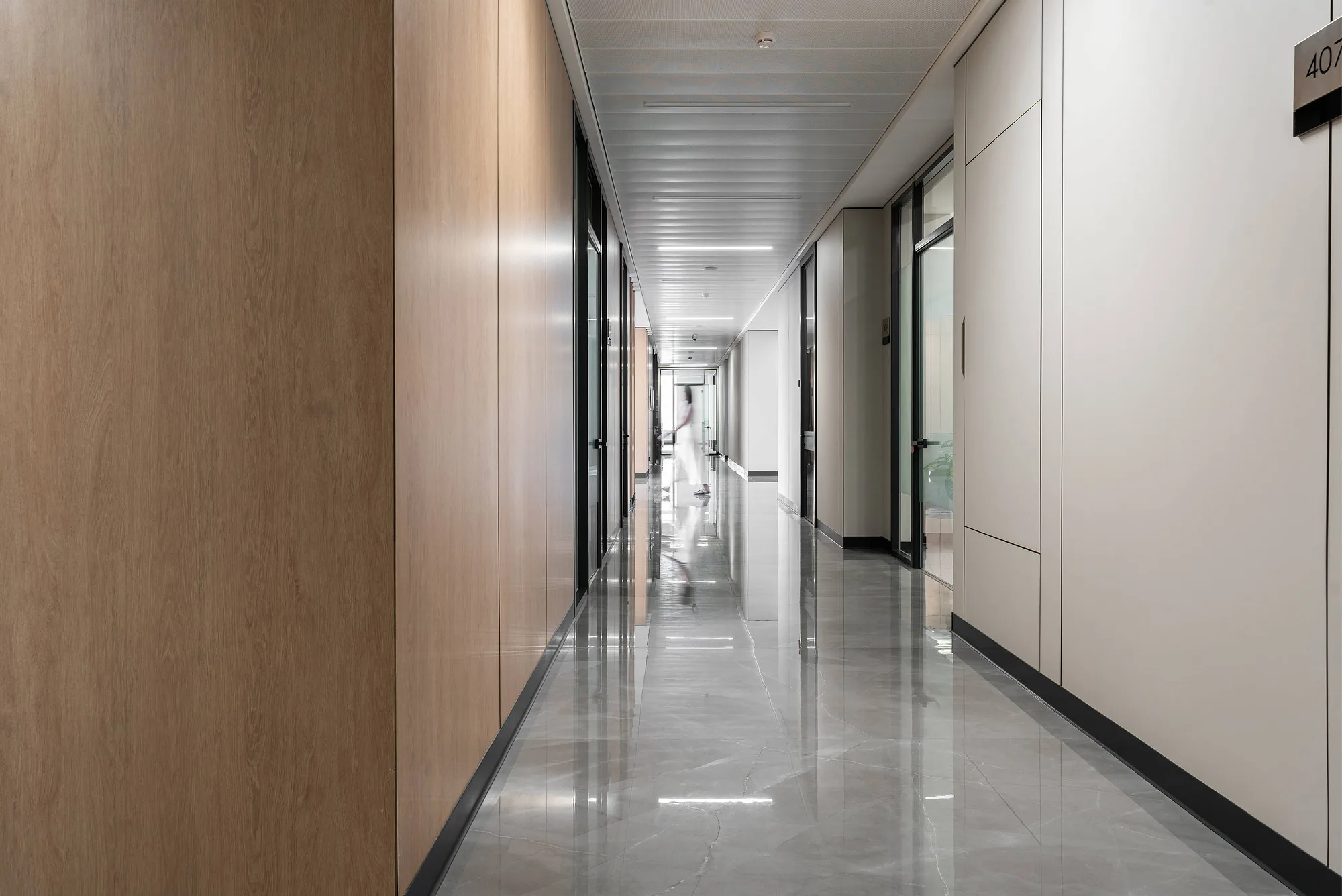 Long office floor corridor with lighting along the wall