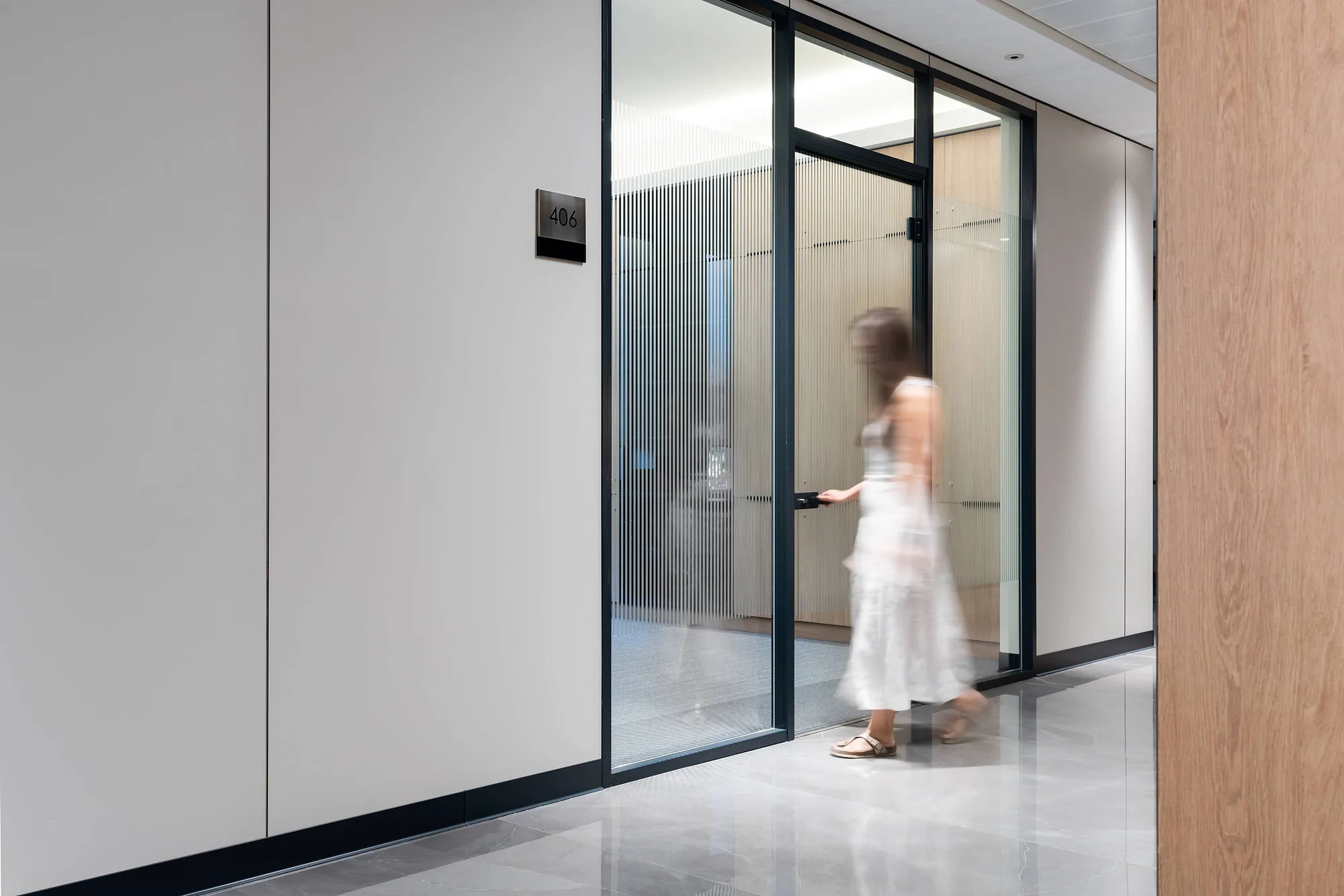 Fluted glass partition in an office floor corridor