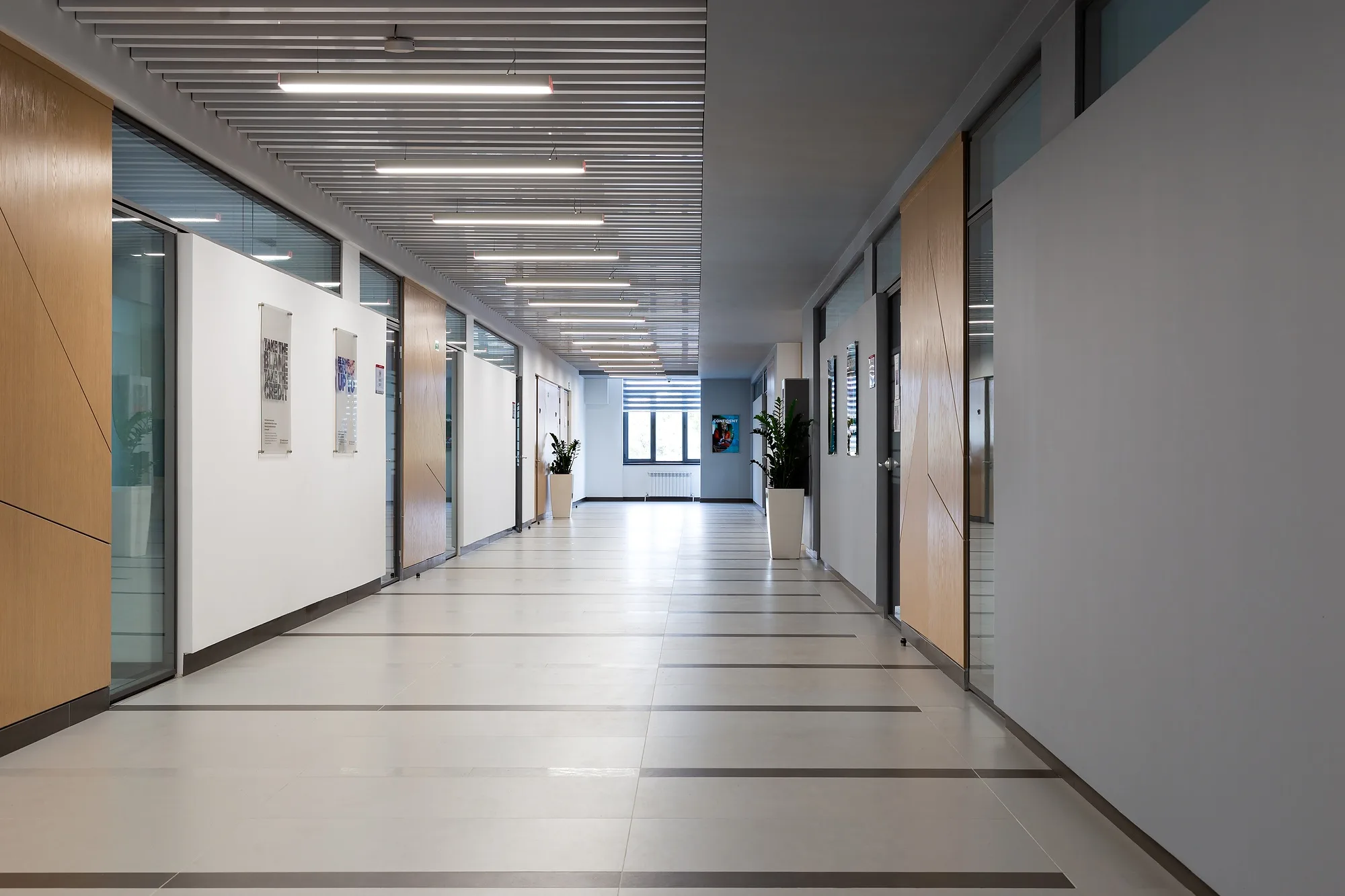 A teaching-wing corridor at CIS International School with glazed classroom doors and overhead lighting