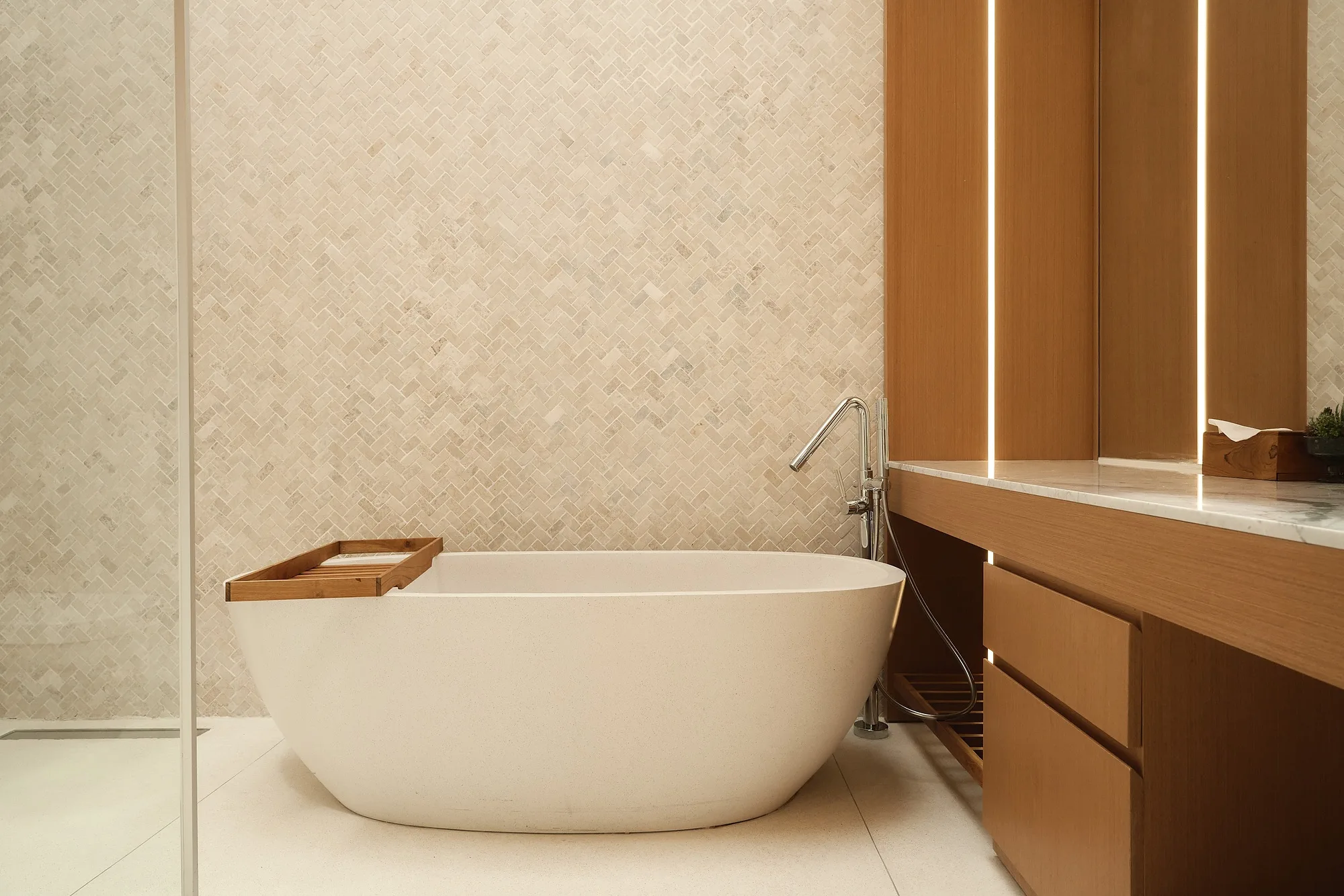 Bathroom with a freestanding bath and backlit timber panels