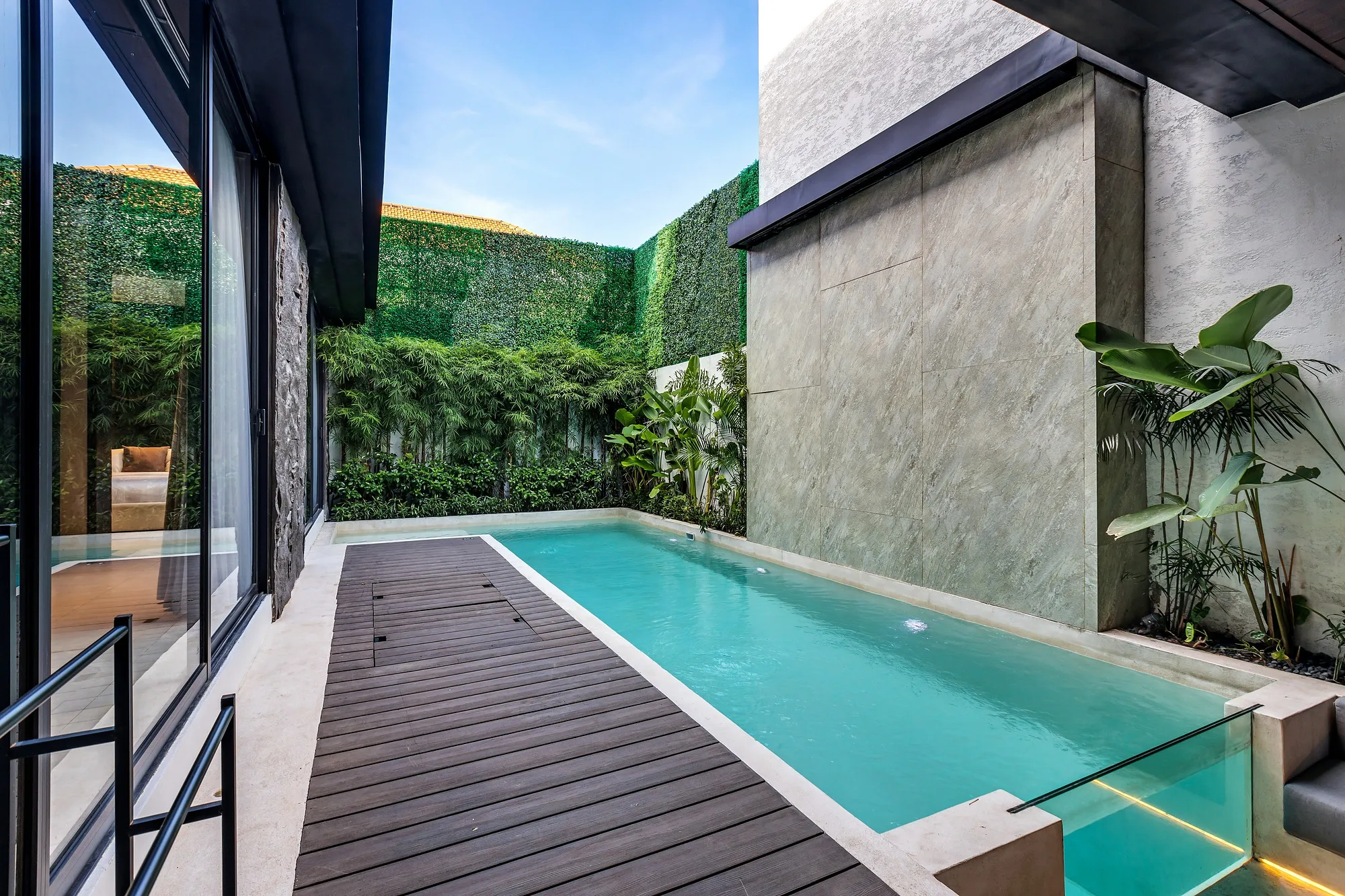 The pool right at the glazing: the water reads as a continuation of the living-room floor