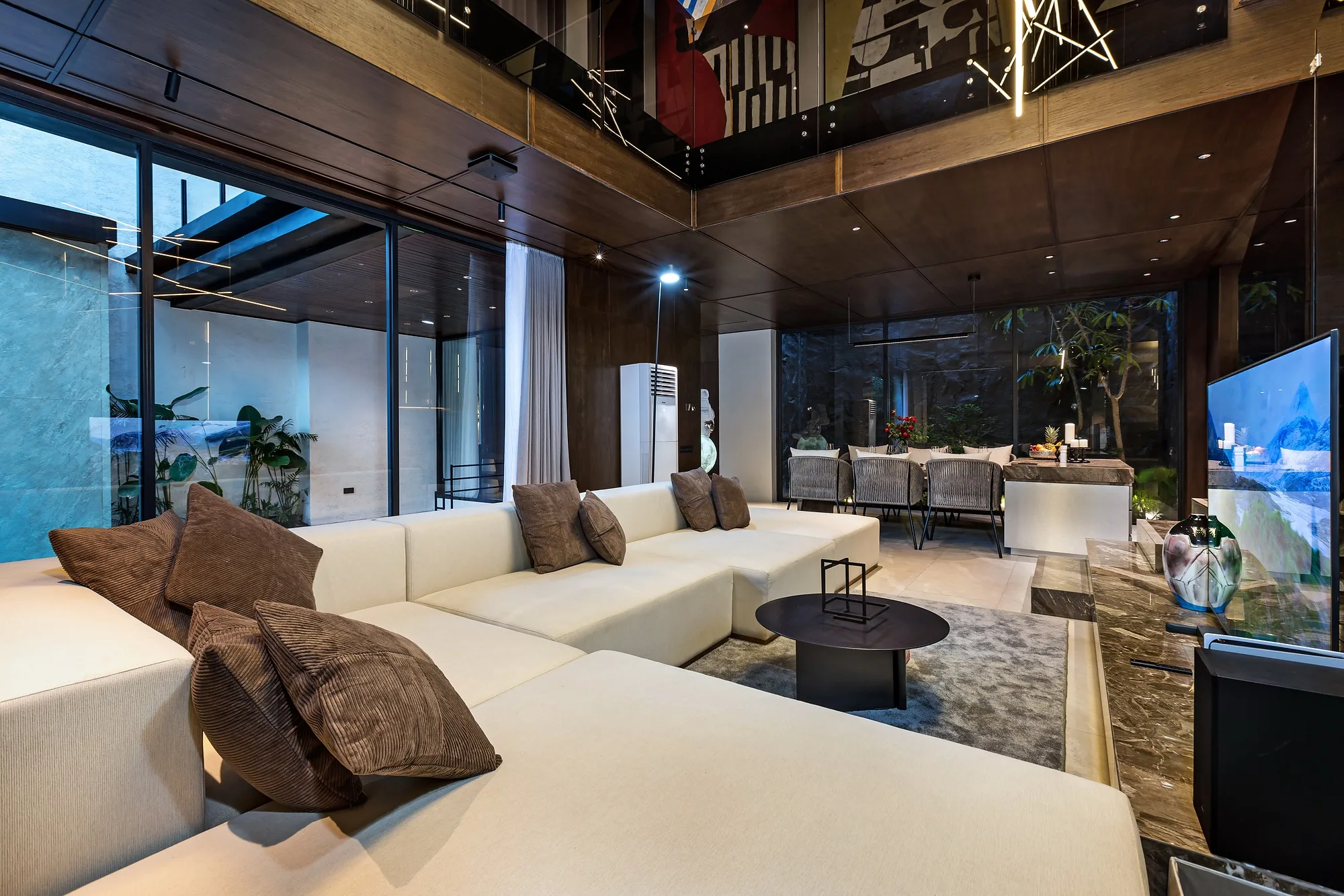 The living room at night: light gathered into pools at the artworks and niches
