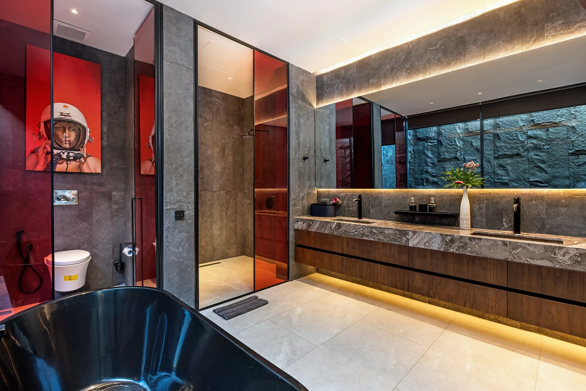 The bathroom with a freestanding tub and a red accent