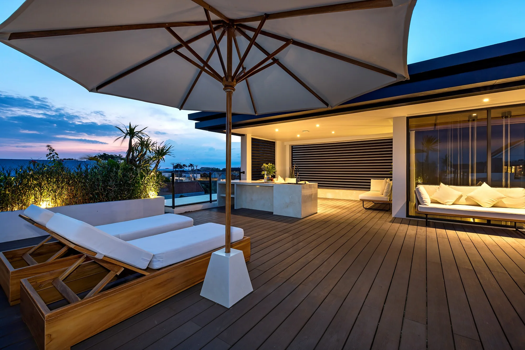 The rooftop lounge with a parasol and an open-air kitchen