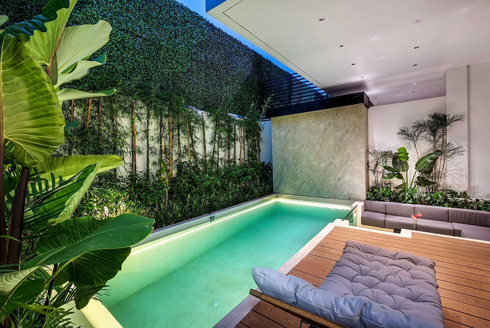 The two-bedroom villa from the courtyard: living room glazing and the pool