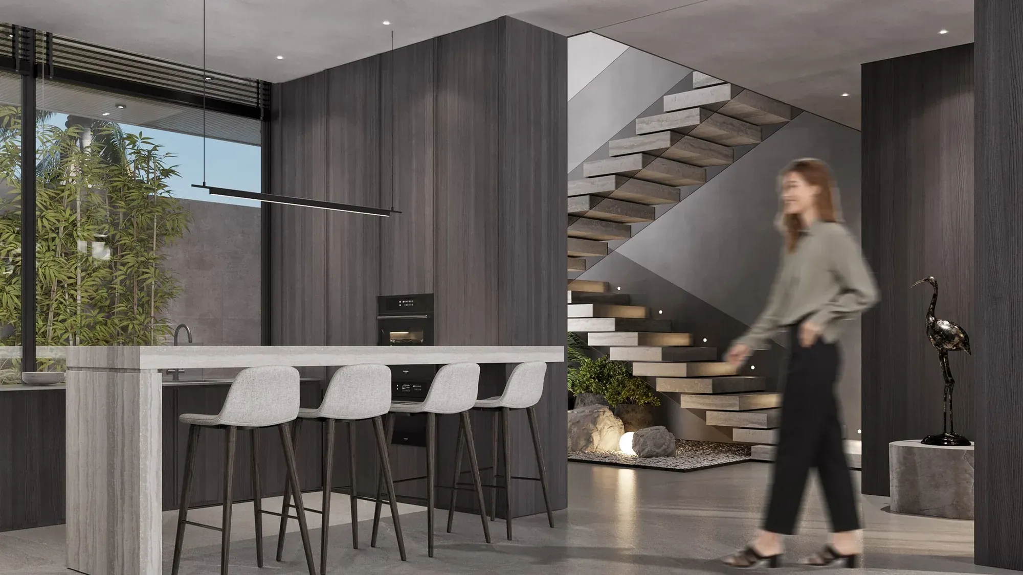 Kitchen island of a Jalan Tegal Cupec villa in Bali: bar seating at the stone top and the stair to the upper level — SAD studio