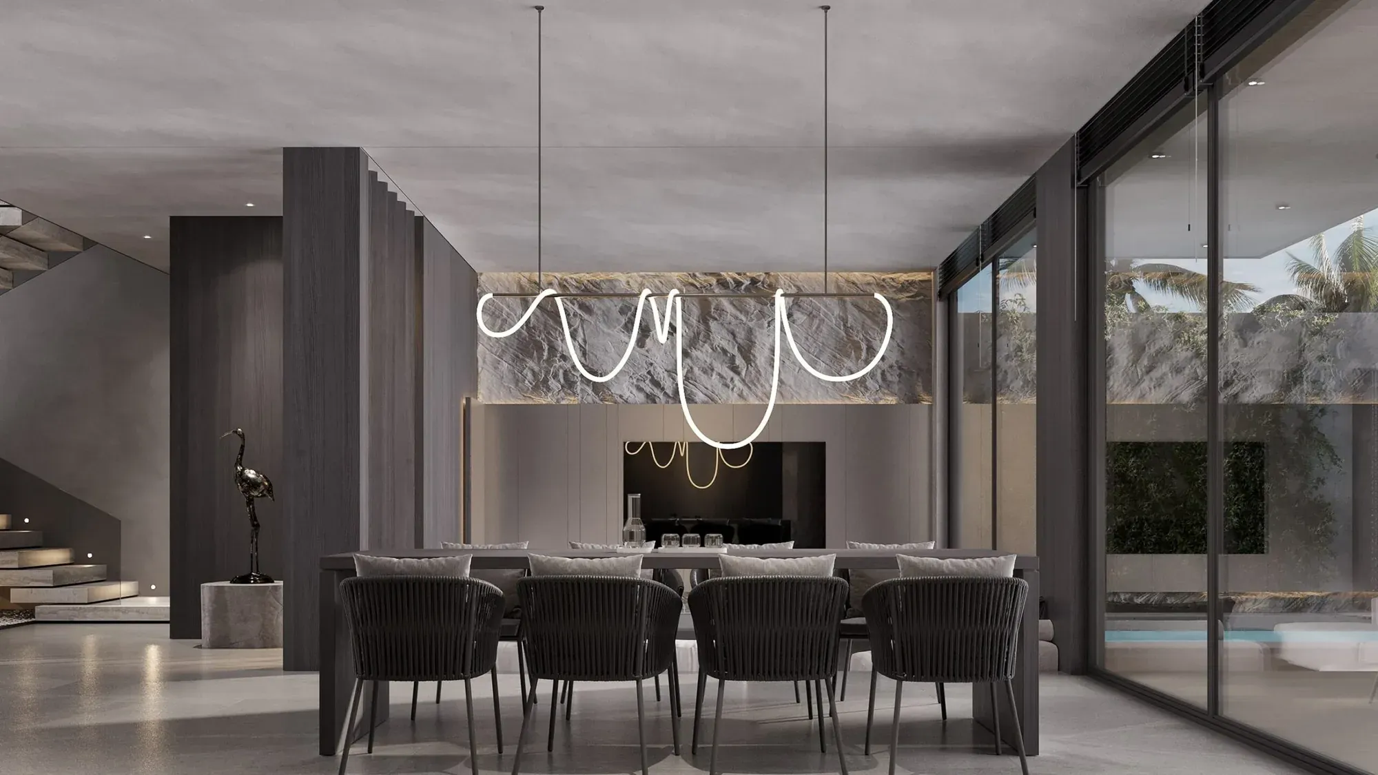Dining area of a Jalan Tegal Cupec villa in Bali: dark timber, a line luminaire and sliding glazing to the pool — SAD studio