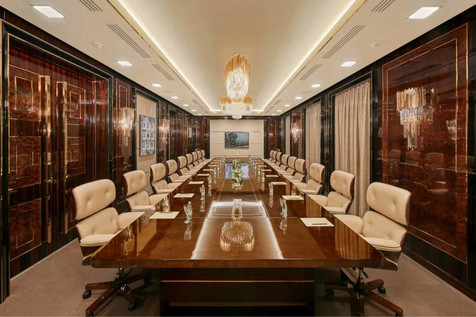 The boardroom of the Mercury business centre: a long table, polished veneer walls and crystal chandeliers