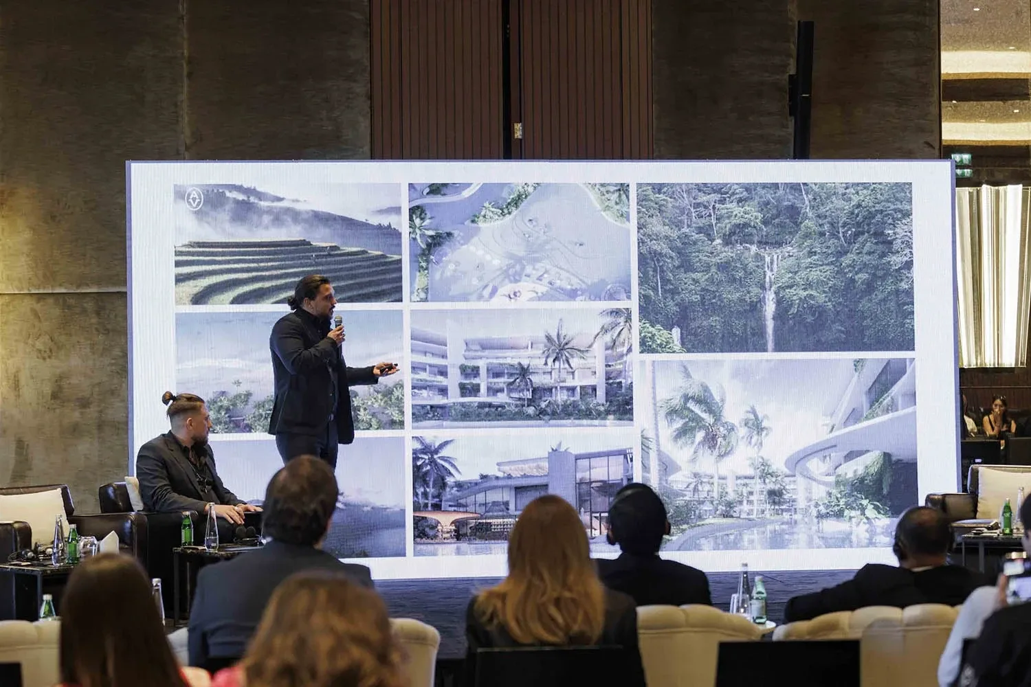 Maxim Oltyan presenting at the Indonesia Investment Roadshow at Bulgari Yacht Club in Dubai, with renderings of Bali projects on the screen behind him