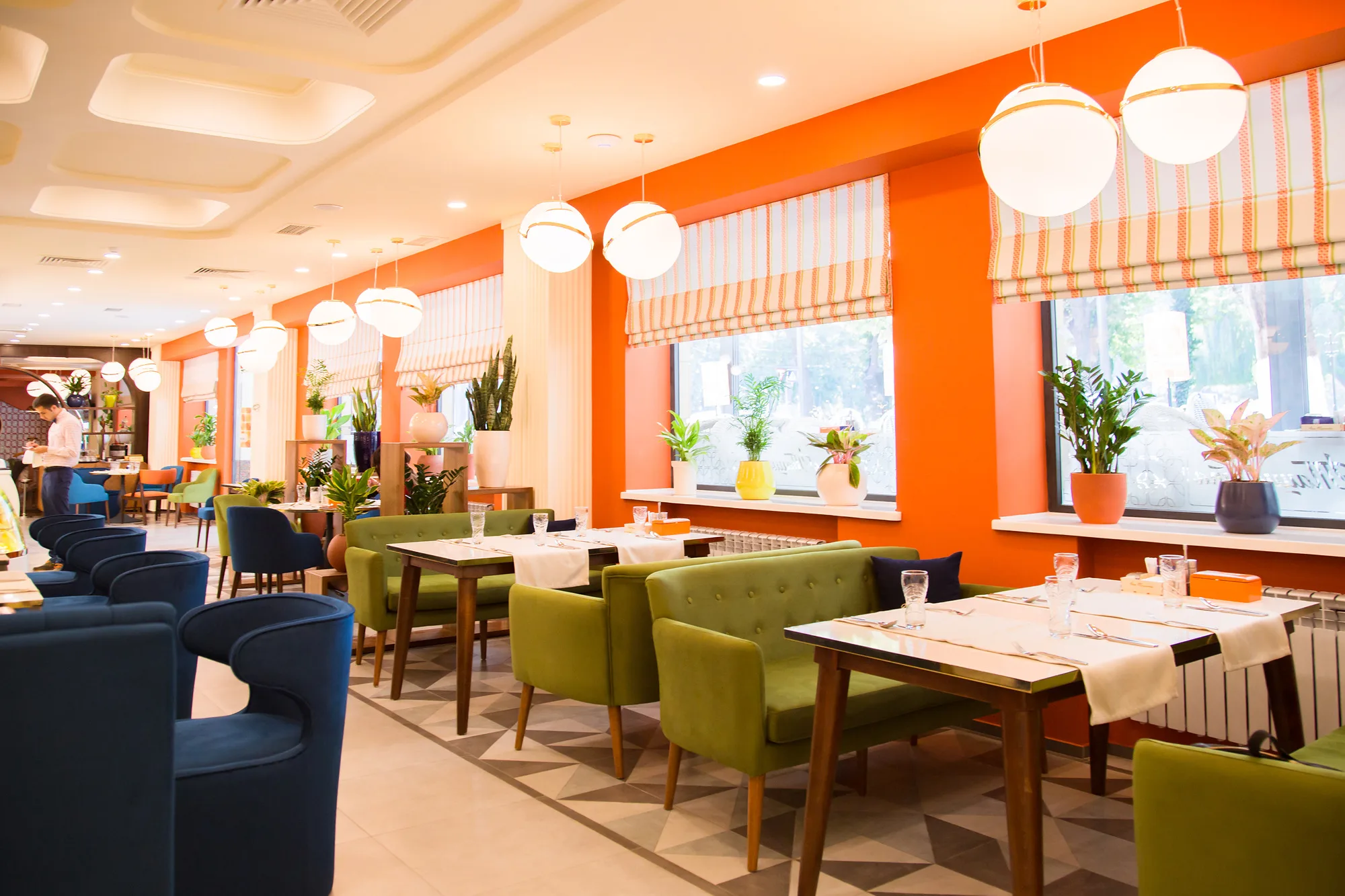 Hall of Ogni Tashkenta by the windows: orange walls, globe pendants and four-seat tables — SAD studio