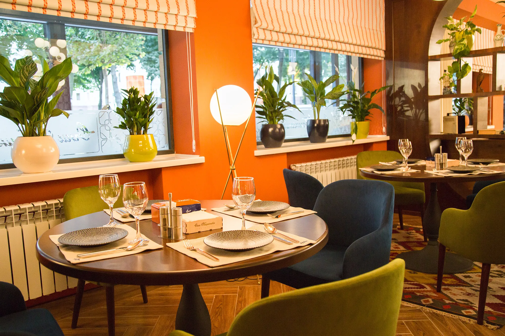Window table at Ogni Tashkenta: the place setting, plants on the sill and the orange wall — SAD studio