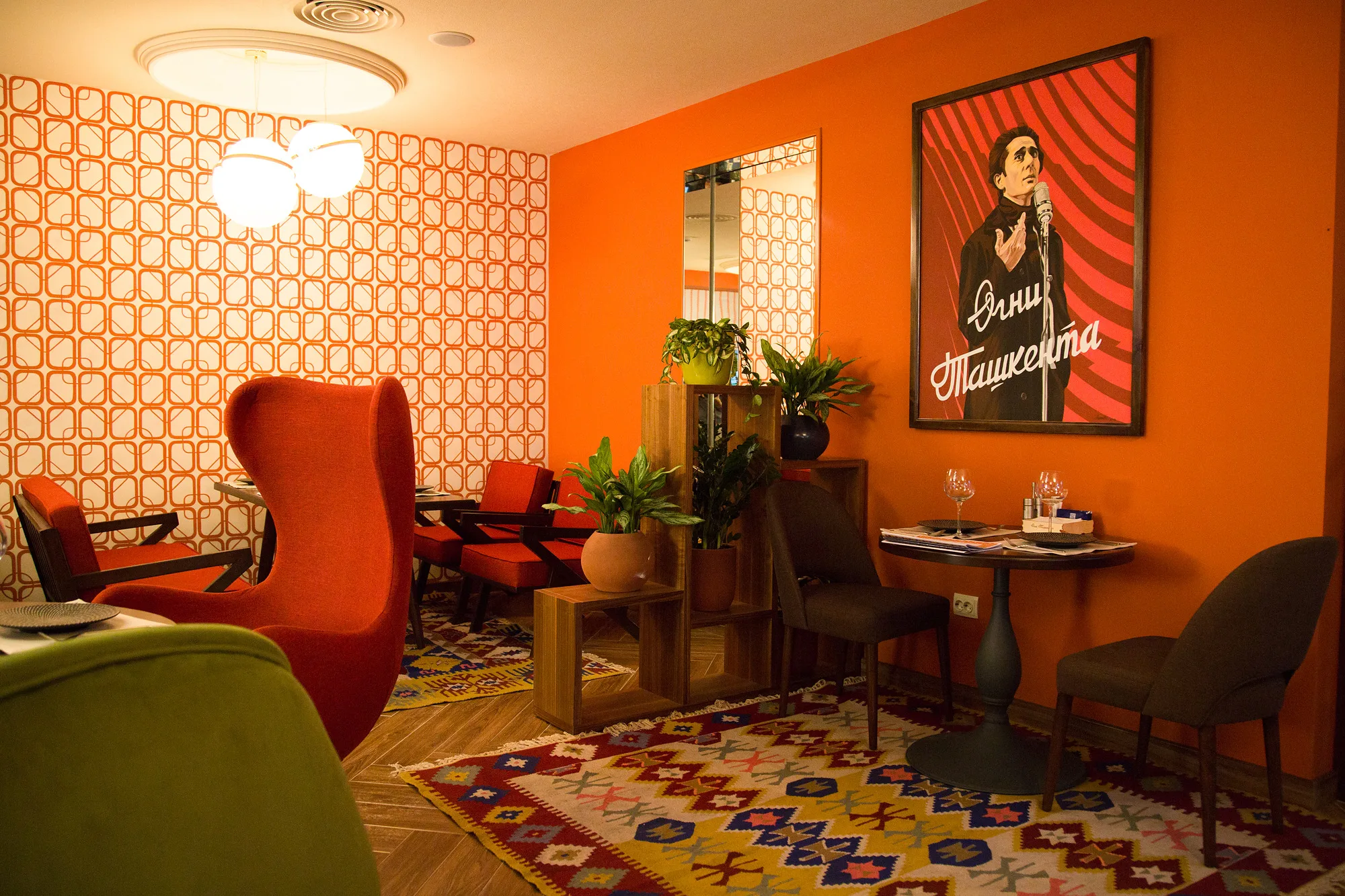 Armchairs at Ogni Tashkenta by the poster with the restaurant name: patterned wallpaper and a rug — SAD studio