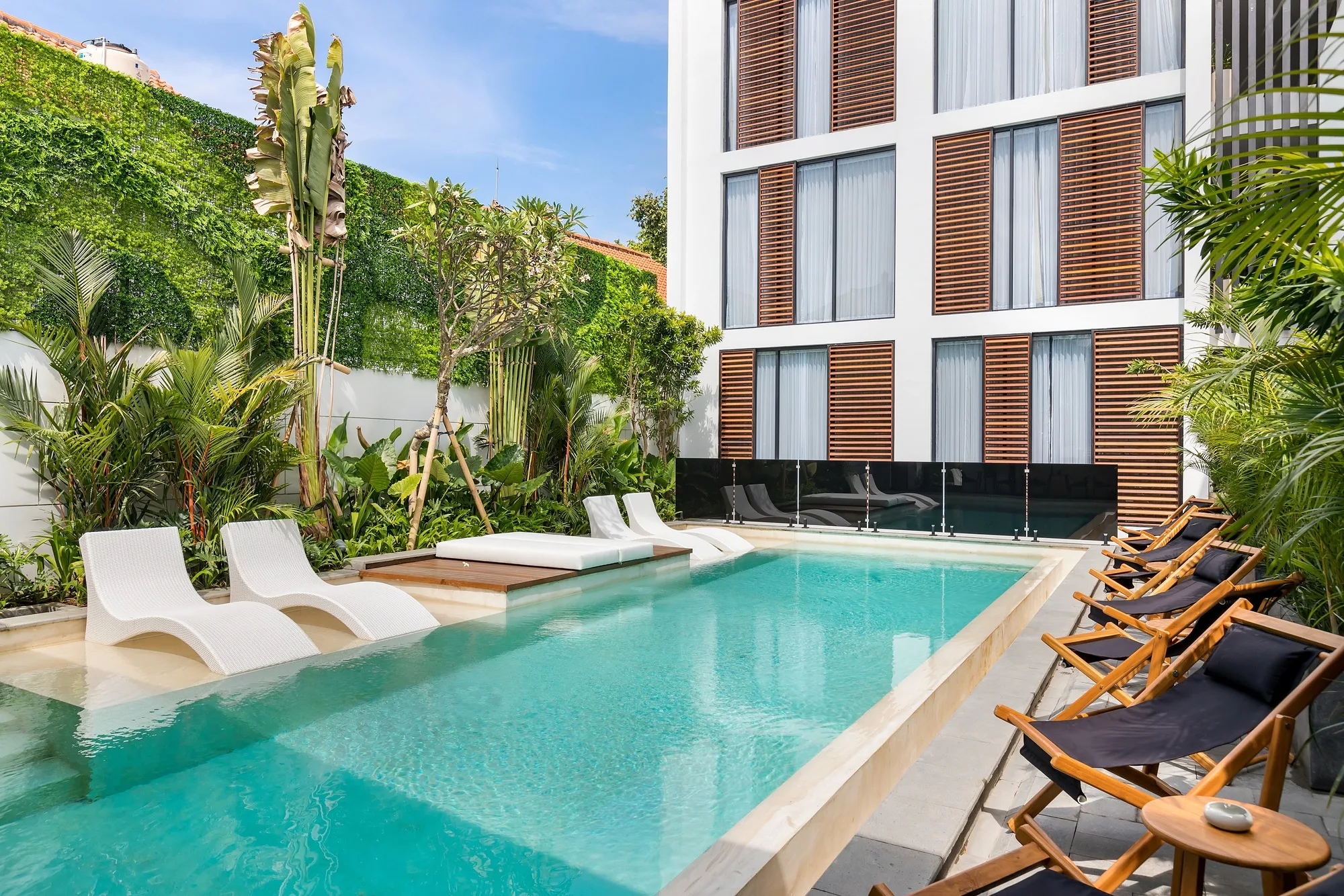 A Pererenan Villas block on Bali: white and terracotta facade panels with the pool along the building