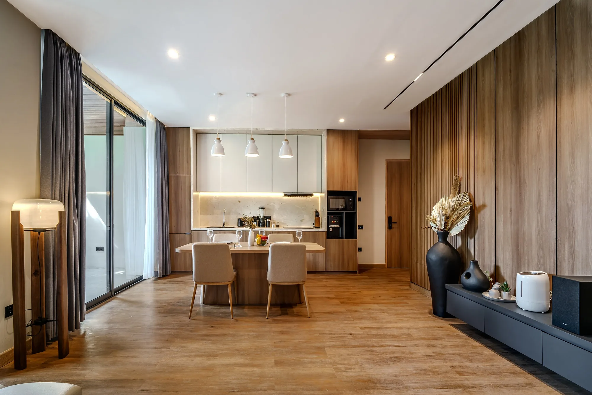 Villa kitchen and living room: timber fronts and the opening to the pool