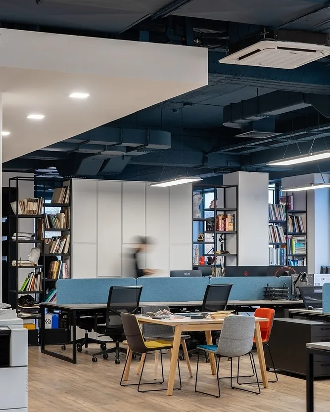 Open-plan workspace at the SAD Tashkent office: bookshelves, workstations and a meeting table