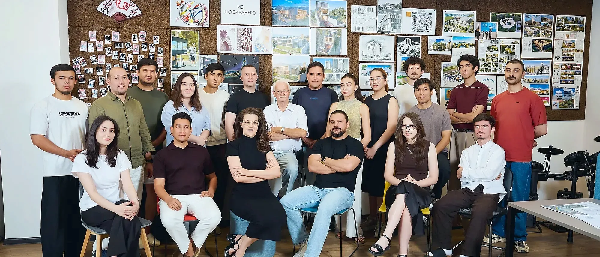 The SAD team at the Tashkent office in front of a wall of projects