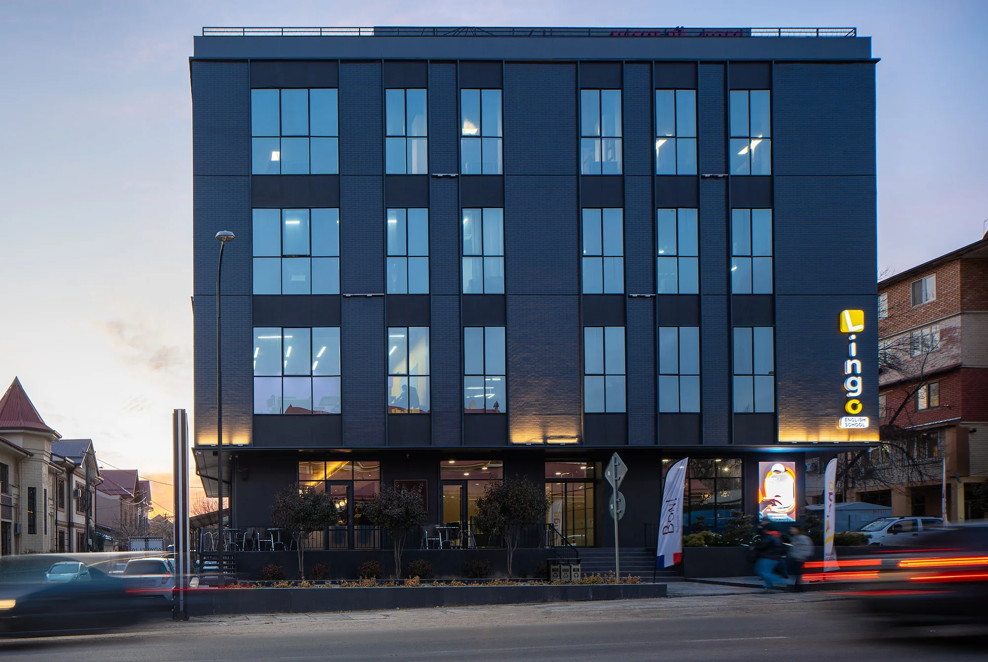 Sayohat business centre in Tashkent: the dark glazed volume on the street corner at dusk — SAD studio