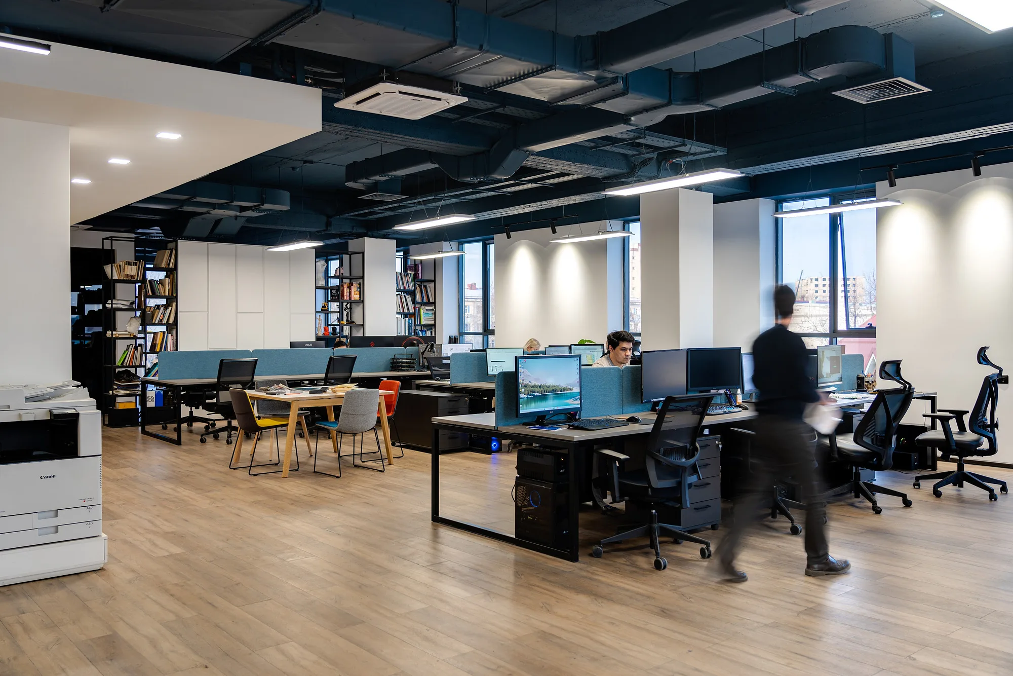 Open workspace of SAD studio: rows of desks, bookshelves and exposed services — SAD studio