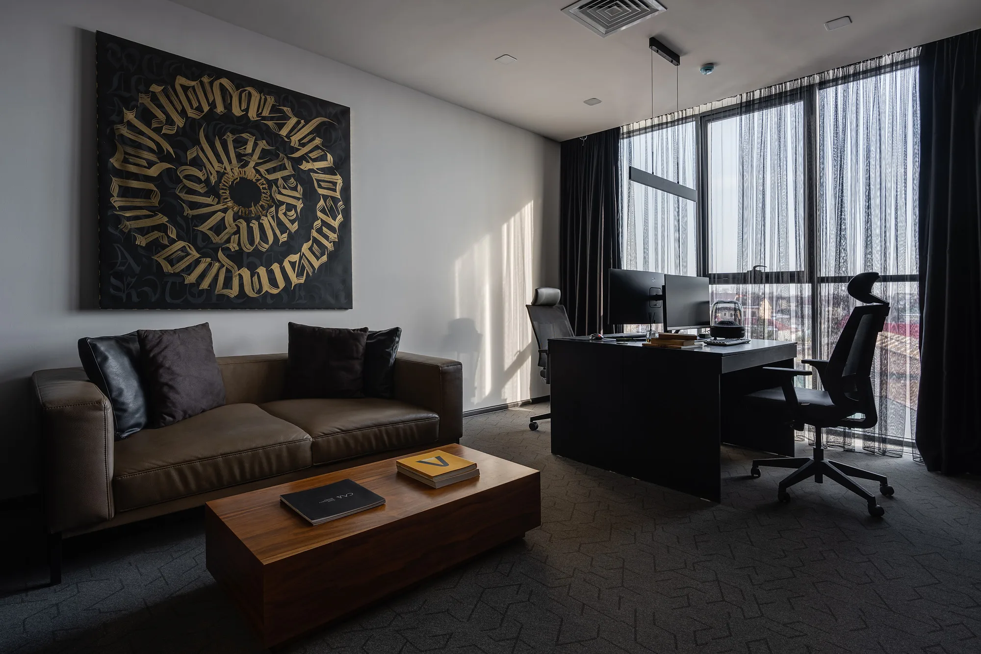 Director office at SAD studio: the desk by the window, a sofa and a panel with eastern calligraphy — SAD studio