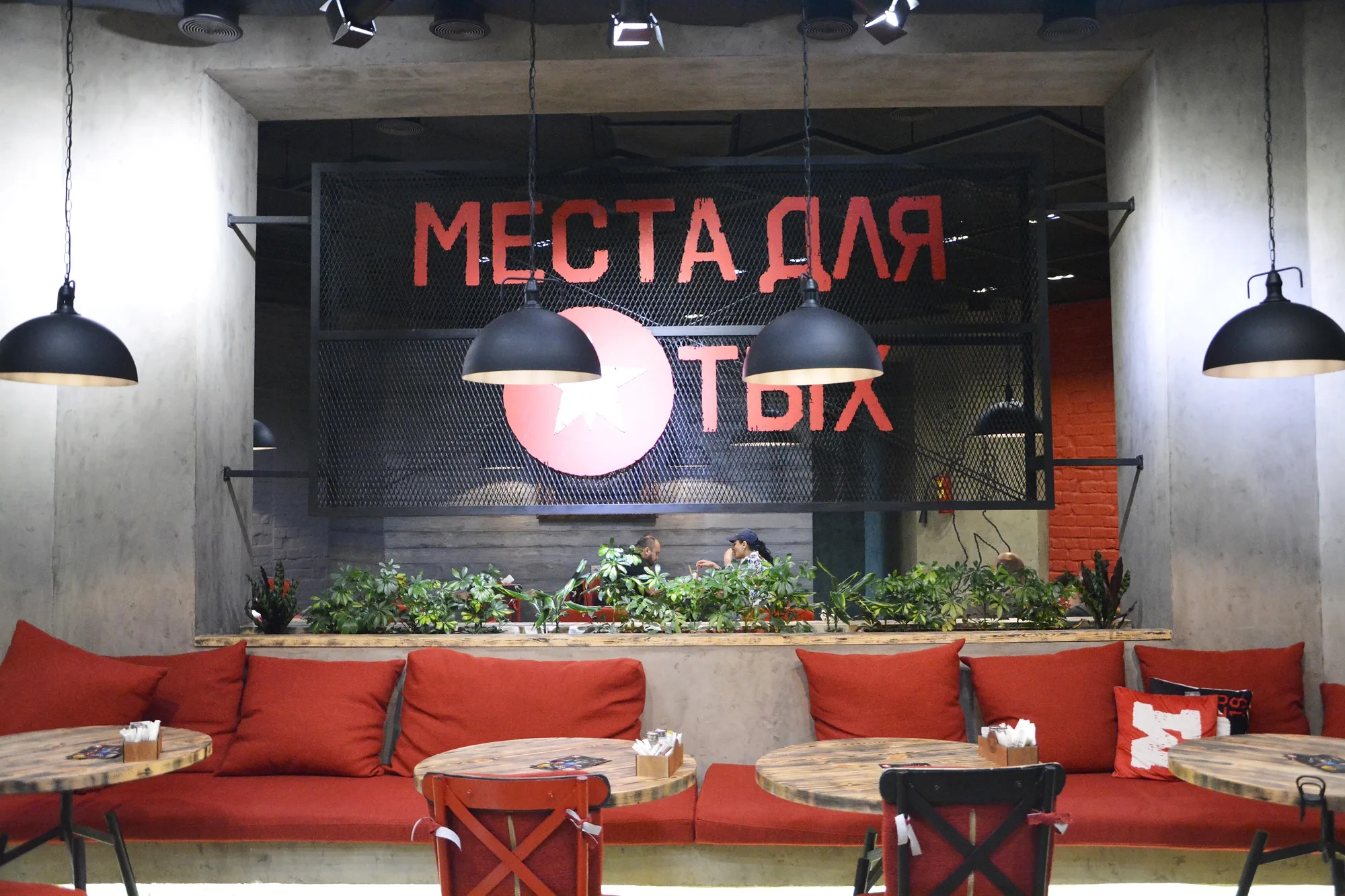 TIM'S Coffee & Roastery in Tashkent: banquettes along the slogan wall — SAD studio