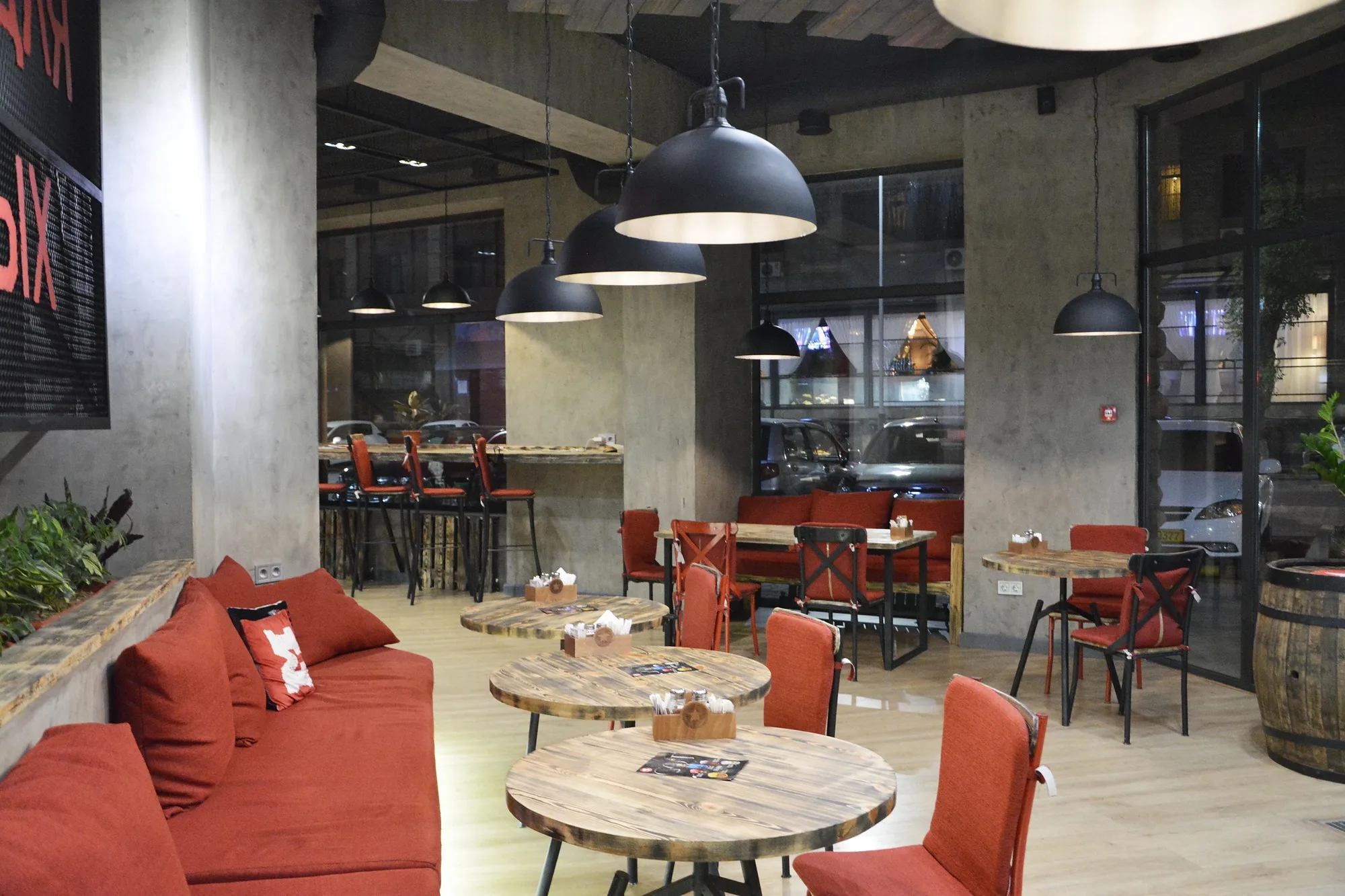 TIM'S Coffee & Roastery in Tashkent: the hall with round tables and red banquettes — SAD studio