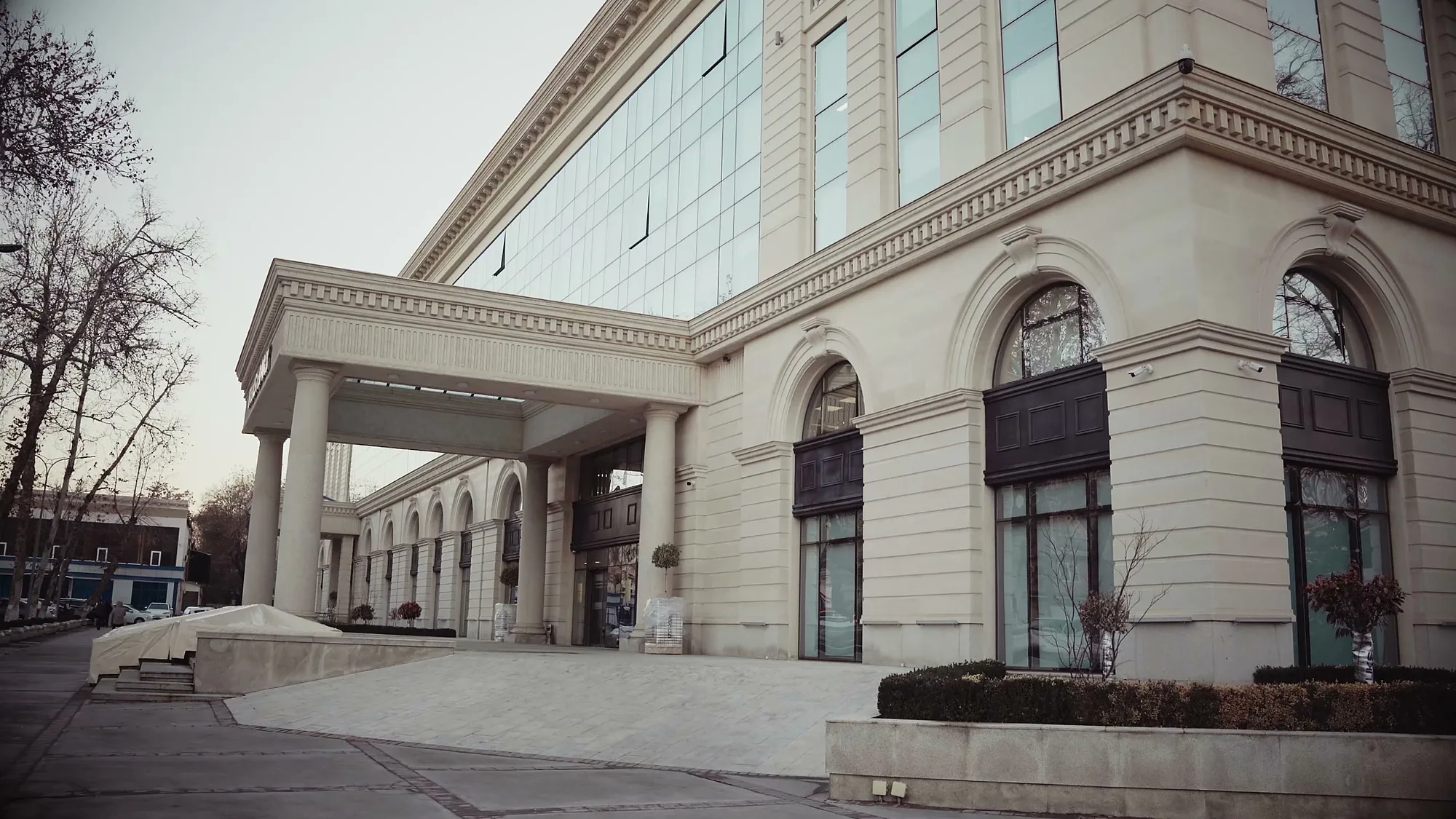 The Trast Bank building in central Tashkent after reconstruction: the classical facade with an arcade and the canopy over the drive — SAD studio