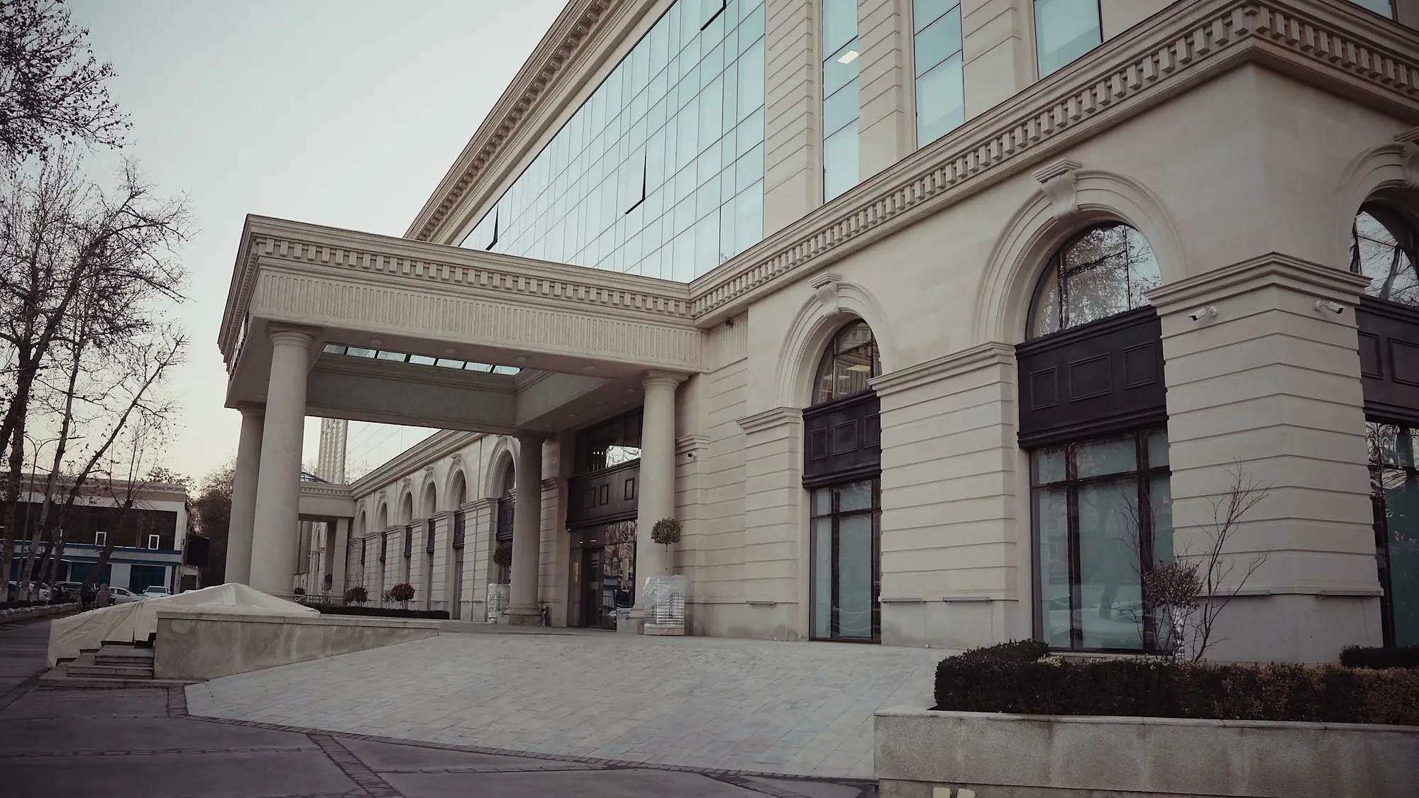 The separate VIP drop-off at Trast Bank in Tashkent: a colonnaded canopy a driver can pull up to — SAD studio