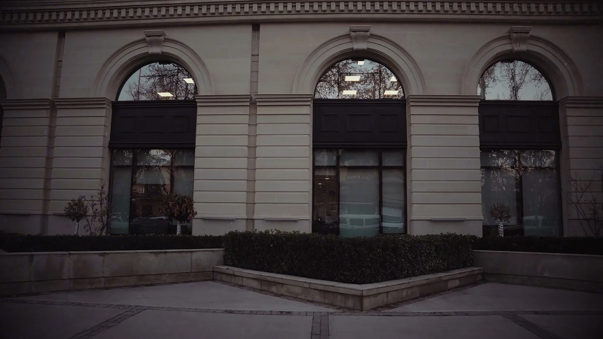 Facade of Trast Bank in Tashkent: arched windows, the cornice and a hedge along the base — SAD studio