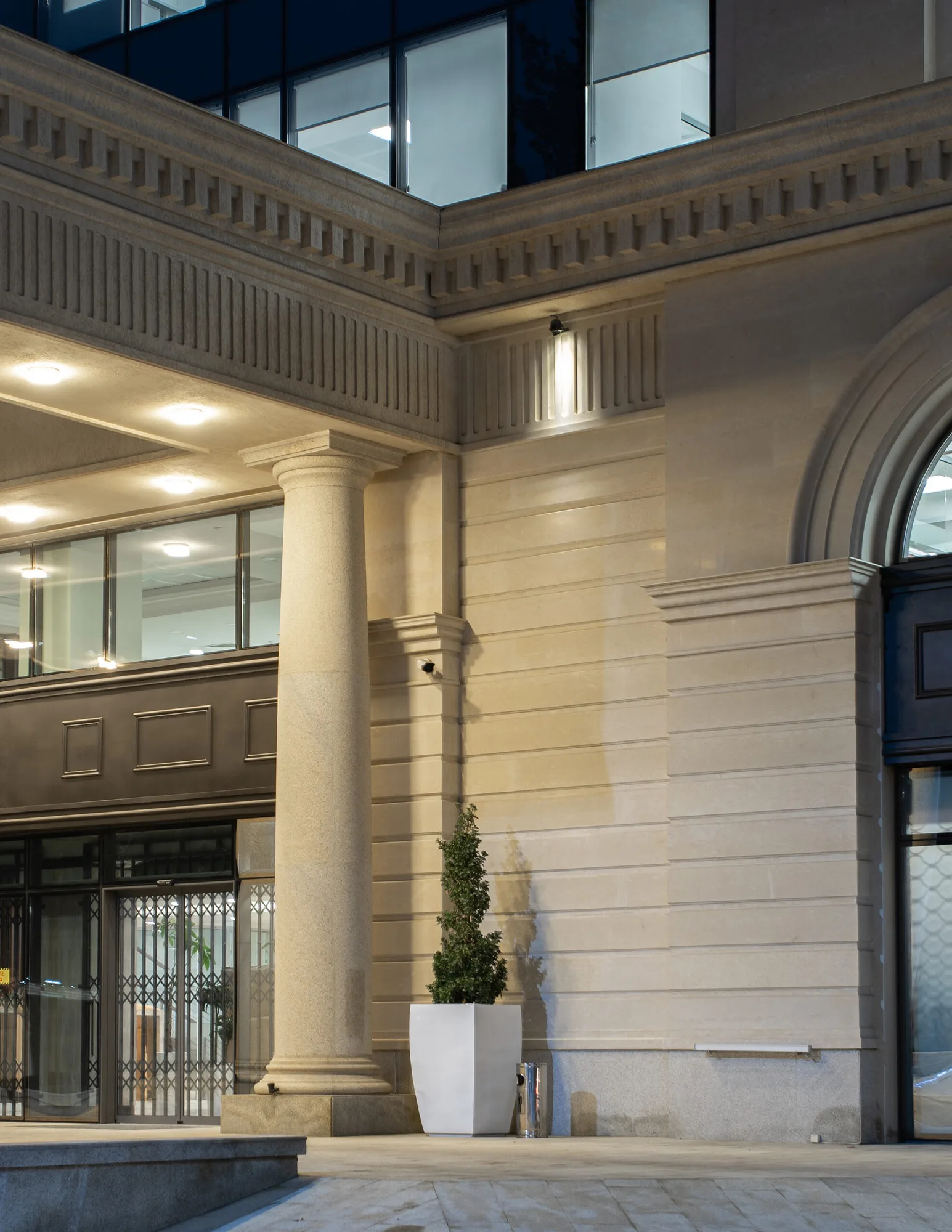 The entrance portico of Trast Bank in Tashkent: a column, arch and stone cladding up close — SAD studio