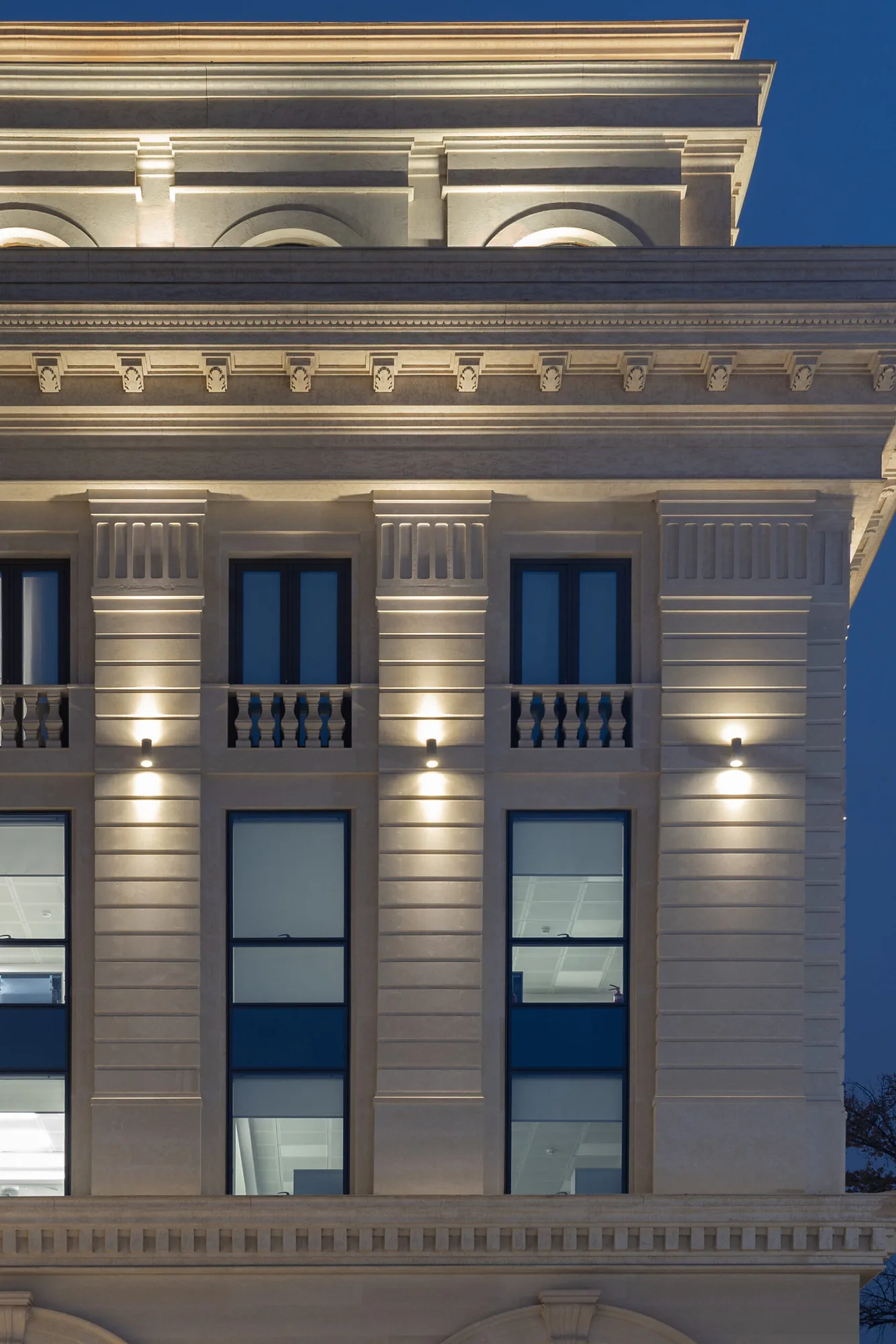 A fragment of the Trast Bank facade in Tashkent: paired windows, pilasters and uplit cornice — SAD studio