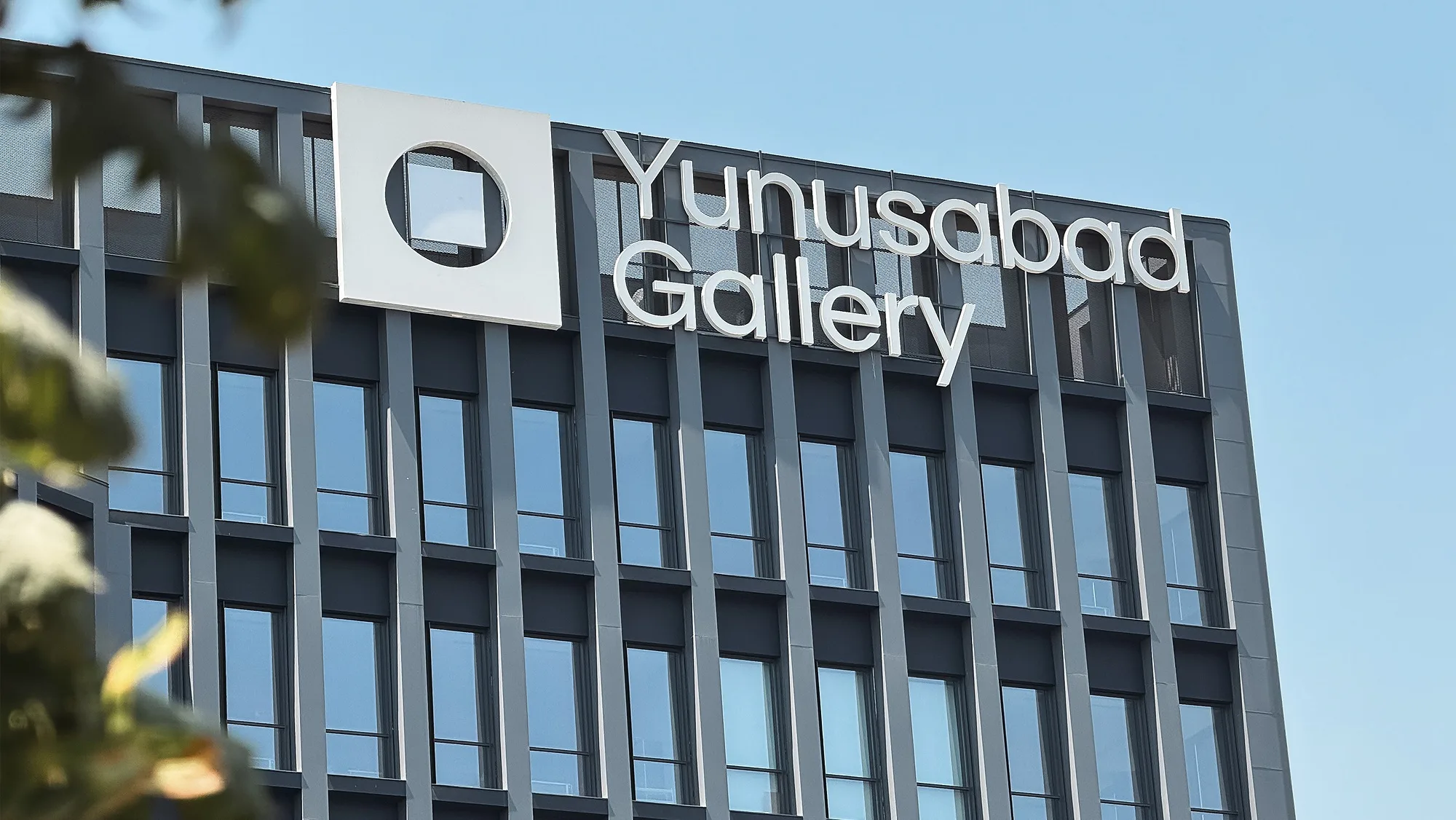 The Yunusabad Gallery sign on the office tower
